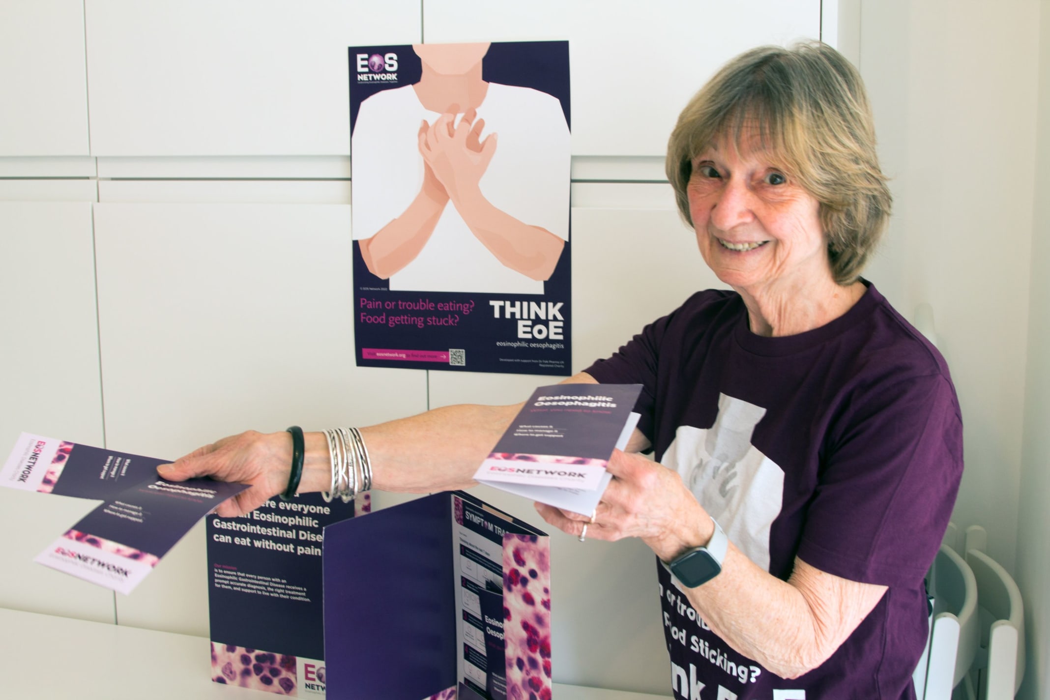 A woman in branding charity t shirt offering leaflets